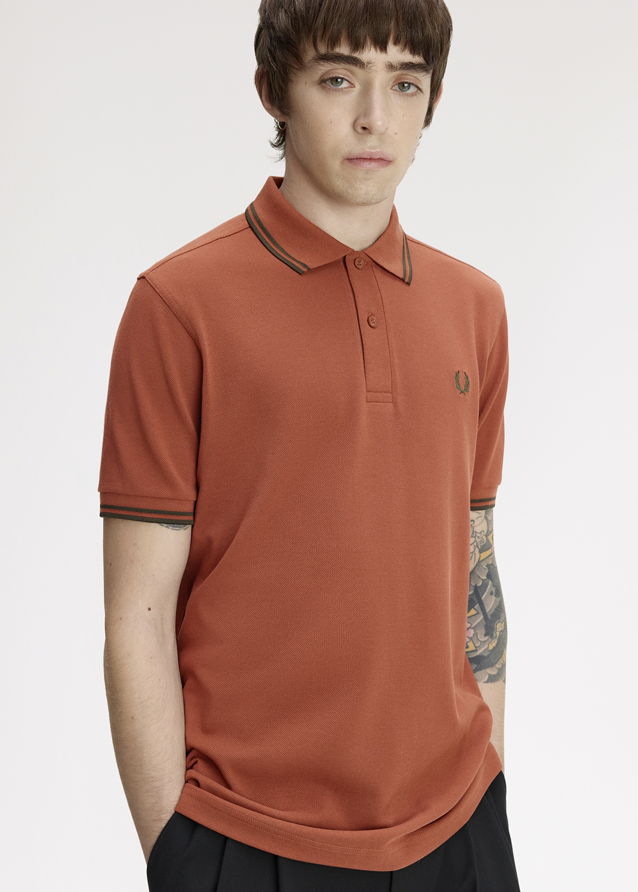 Male model wearing a M3600 Twin Tipped Fred Perry Shirt in Brandy / Night Green / Night Green