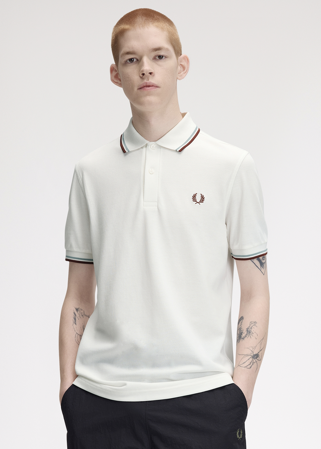 Male model wearing a M3600 Twin Tipped Fred Perry Shirt in Snow White / Silver Blue / Brandy