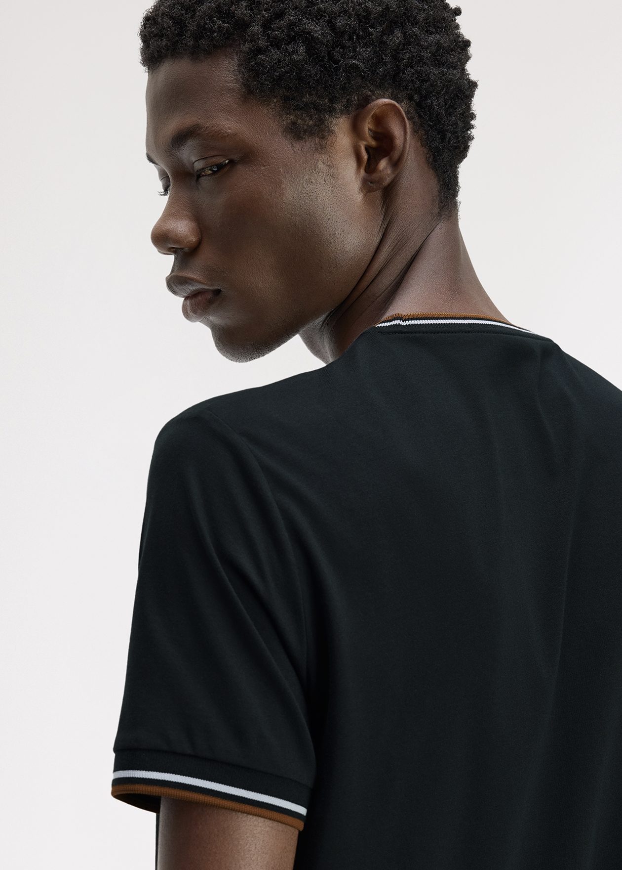 Male model wearing a Fred Perry Twin Tipped T-Shirt in Night Green / Dusky Blue / Dark Caramel