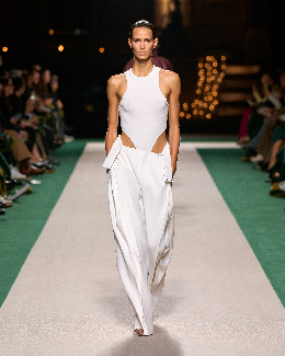 Women in white trousers and white top on the runway 