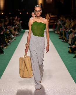 Women in grey trousers and green top on the runway 