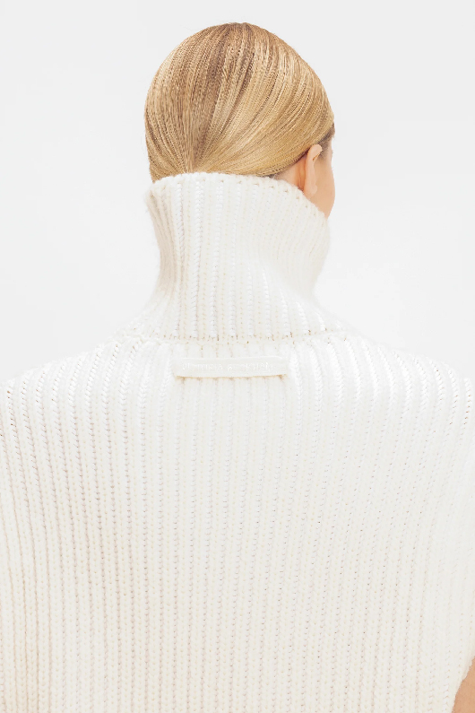 A white high neck sleeveless jumper 