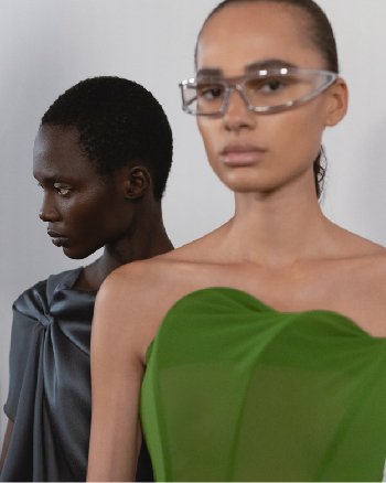 Two women one in a green top and the other in a grey dress