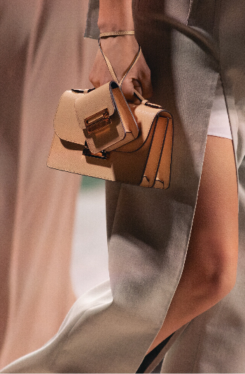 A small bag in beige with a mini bag on top 